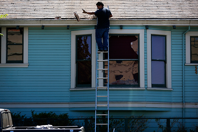 A man removes part of a fallen chimney from the roof of a house after an earthquake in Napa, California August 24, 2014 (Reuters / Stephen Lam)