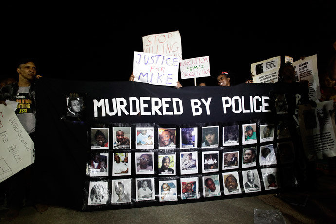 Images of people shot by police officers are displayed by demonstrators protesting the fatal shooting of Michael Brown in Ferguson, Missouri August 23, 2014.(Reuters / Joshua Lott)