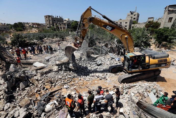 Palestinians gather as rescue workers search for victims from under the rubble of a house, which witnesses said was destroyed by an Israeli air strike, in Beit Lahiya in the northern Gaza Strip August 25, 2014.(Reuters / Mohammed Salem)