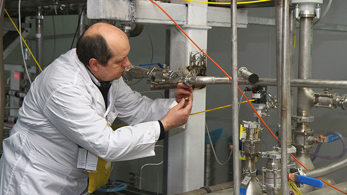 An unidentified International Atomic Energy Agency (IAEA) inspector disconnects the connections between the twin cascades for 20 percent uranium production at nuclear power plant of Natanz (AFP Photo / Kazem Ghane)