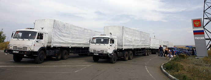 People stand by a humanitarian convoy at the Donetsk-Izvarino customs control checkpoint, some 30 km outside Kamensk-Shakhtinsky in the Rostov Region, on August 22, 2014. (AFP Photo / Sergey Venyavsky)