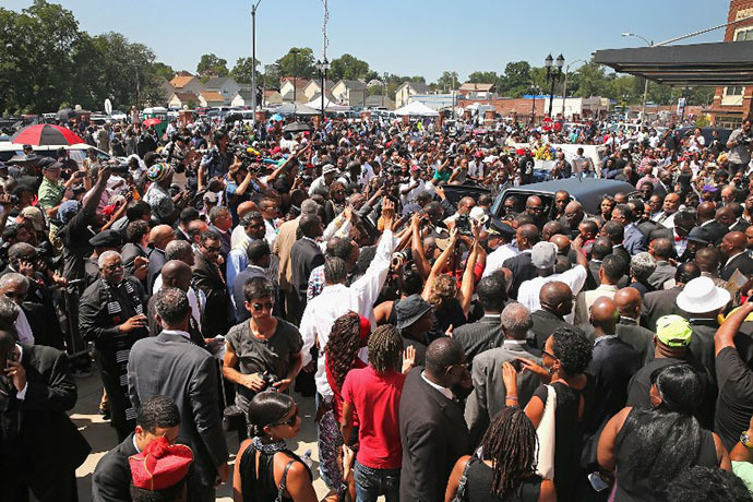 Under a crush of mourners and media the remains of Michael Brown are loaded into a hearse following his funeral services at the Friendly Temple Missionary Baptist Church on August 25, 2014 in St. Louis, Missouri. (AFP Photo / Getty Images / Scott Olson)