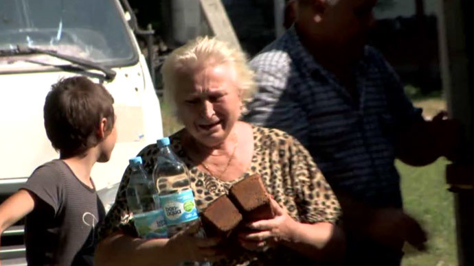 A local resident holds bread in the city of Yasinovata, Donetsk Region, eastern Ukraine (screenshot from RT video)