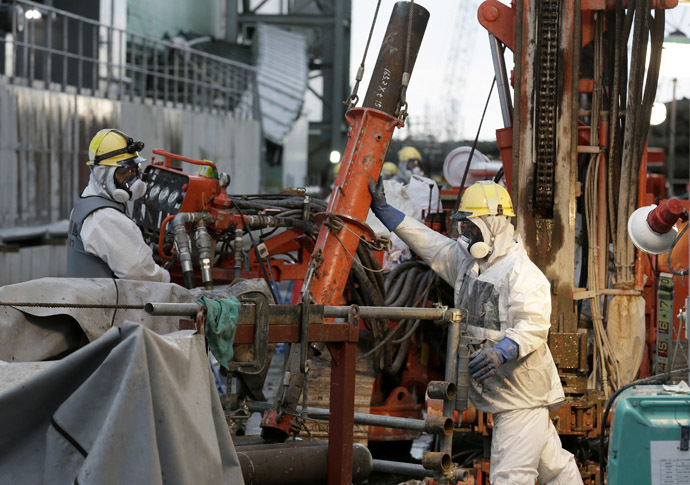 Workers prepare frozen pipes during operations to construct an underground ice wall at Tokyo Electric Power Co.'s (Tepco) tsunami-crippled Fukushima Daiichi nuclear power plant in Fukushima Prefecture July 9, 2014. (Reuters/Kimimasa Mayama)