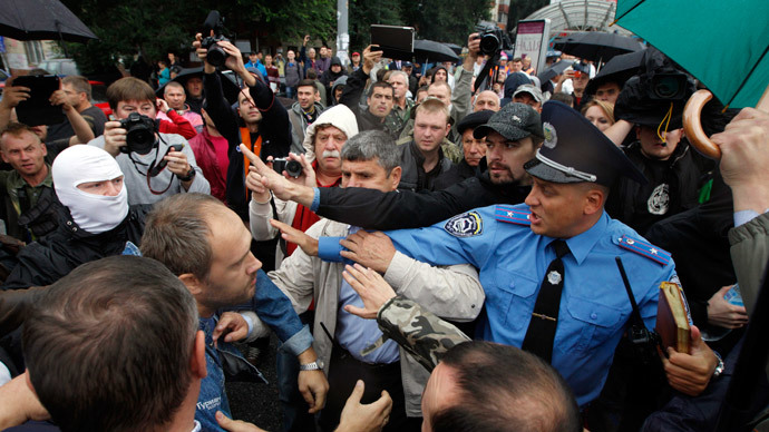 A police officer tries to prevent activists and relatives of soldiers who say that the soldiers are surrounded by self-defense forces in eastern Ukraine, from getting into the defence ministry building during a protest in Kiev August 28, 2014.(Reuters / Valentyn Ogirenko)