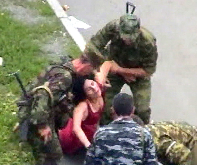 This TV-grab image shows Russian soldiers helping an injured woman during the rescure operation in Beslan, North Ossetia 03 September 2004. (AFP/NTV)