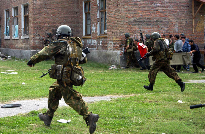 Russian special forces soldiers run during the rescue operation of Beslan's school, northern Ossetia, 03 September 2004. (AFP Photo/Yuri Tutov)