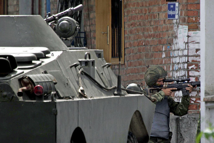 A Russian special forces soldier aims at a position outside the school, where a group of gunmen, wearing belts laden with explosives, are holding hostage some 350 people in the northern Ossetian town of Beslan, some 30 kms outside Vladikavkaz, 02 September 2004. (AFP/ITAR-TASS)