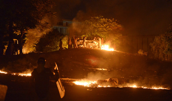 Supporters of cricketer-turned-politician Imran Khan and Canadian cleric Tahir ul Qadri take position alongside fire near the prime minister's residence following clashes with security forces in Islamabad on August 31, 2014. (AFP Photo)