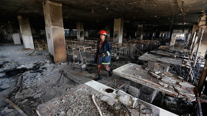 A firefighter inspects the Standard Group garment factory which was on fire in Gazipur November 29, 2013.(Reuters / Andrew Biraj)