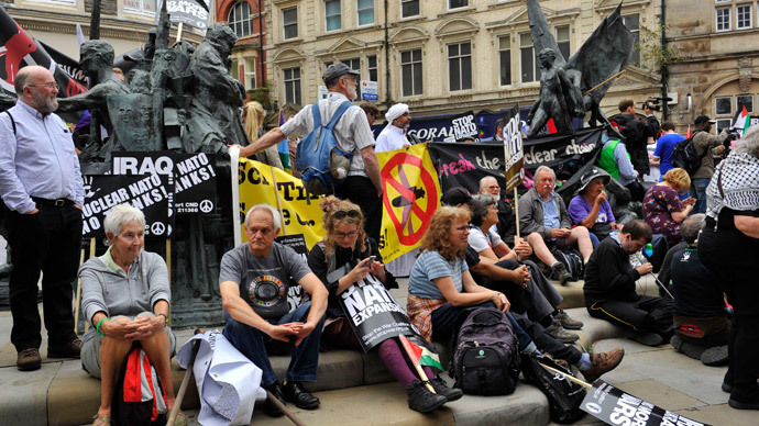 Demonstrators sit on the ground after taking part in an anti-war protest march in Newport, Wales, August 30, 2014.(Reuters / Rebecca Naden)