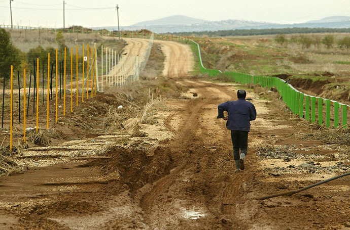 File photo. A Palestinian man, who works in Israel, walks back home as he crosses the green line separating the Jenin area in the north of the West Bank from the Israeli part at the agricultural village of Ram-On. (AFP Photo / Sven Nackstrand)