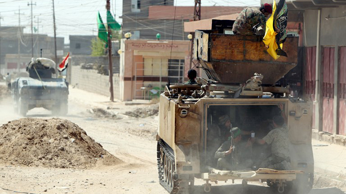 Iraqi Shiite militia fighters ride in an armoured personnel carrier (APC) after pushing back Islamic State (IS) militants on September 3, 2014, on the road between Amerli and Tikrit. (AFP Photo / Ahmad Al-Rubaye)
