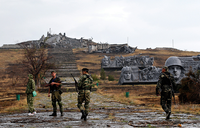 Anti-goverment fighters walk towards destroyed war memorial at Savur-Mohyla, a hill east of the city of Donetsk, August 28, 2014 (Reuters / Maxim Shemetov)