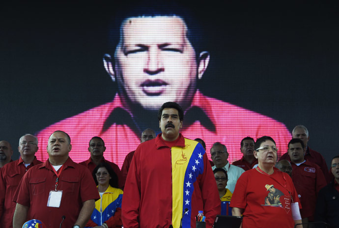 Venezuelan President Nicolas Maduro (C) and the president of the Parliament Diosdado Cabello (2-L) are seen among other authorities and guests during the United Socialist Party of Venezuela's (PSUV) annual congress on July 31, 2014, at Caracas' Mountain Barracks, where the remains of Venezuelan former president Hugo Chavez (on screen) rest. (AFP Photo/Juan Barreto)