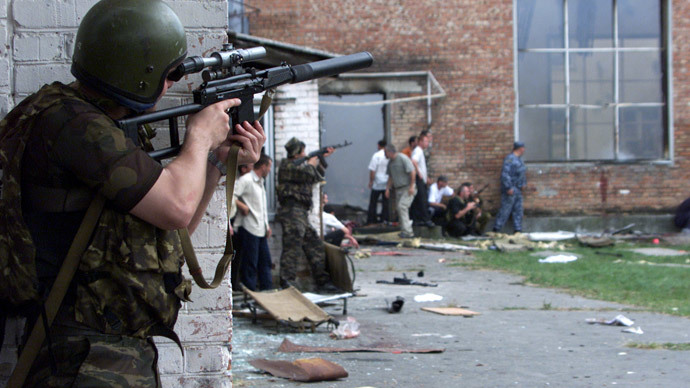 Russian special forces troops take cover while soldiers stormed a school building seized by heavily armed masked men and women in the town of Beslan in the province of North Ossetia near Chechnya, September 3, 2004. (Reuters / S.Dal GD)