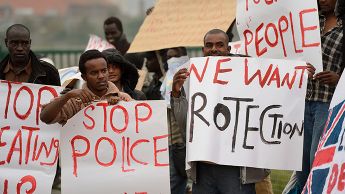 Migrants hold placards as they demonstrate on September 5, 2014 in Calais, northern France, to protest their living conditions in Calais. (AFP Photo / Denis Charlet)