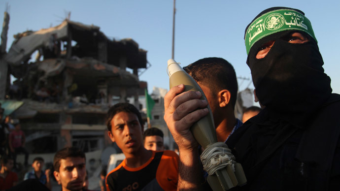 A Hamas militant displays a mortar shell as he celebrates what the militants say was a victory over Israel, in front of a destroyed house in the Shejaia neighborhood east of Gaza City August 27, 2014.(Reuters / Majdi Fathi)