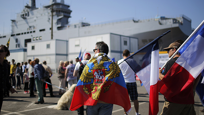 People hold Russian flags, French flags and placards during a demonstration supporting a contract to deliver the Mistral-class helicopter carrier Vladivostok warship to Russia, at the STX Les Chantiers de l'Atlantique shipyard site in Saint-Nazaire, September 7, 2014. (Reuters / Stephane Mahe)