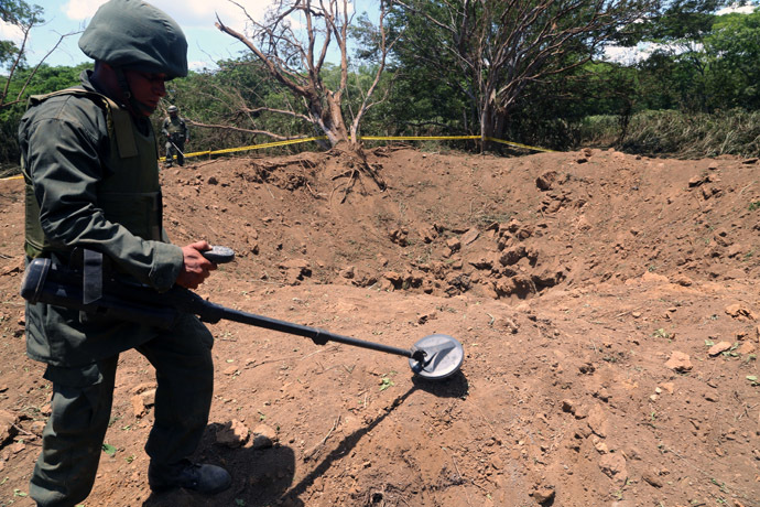 Handout picture released by the Nicaraguan presidency press office showing a Nicaraguan soldier checking the site where an alleged meteorite struck on September 7, 2014 in Managua. (AFP Photo)
