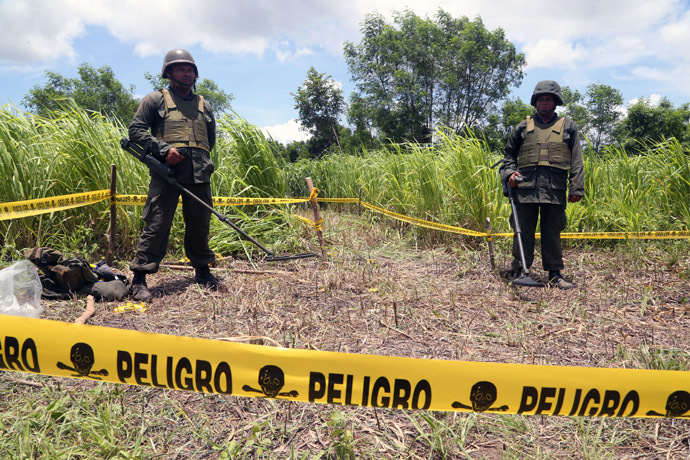 Handout picture released by the Nicaraguan presidency press office showing two Nicaraguan soldiers standing guard in the site where an alleged meteorite struck on September 7, 2014 in Managua. (AFP Photo)