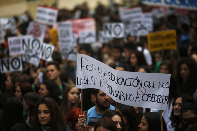 Students hold a banner that reads, "For an education that teaches us to think, not to obey", on the second day of a 48-hour nationwide student strike to protest against rising fees and educational cuts in Madrid March 27, 2014.(Reuters/Susana Vera)