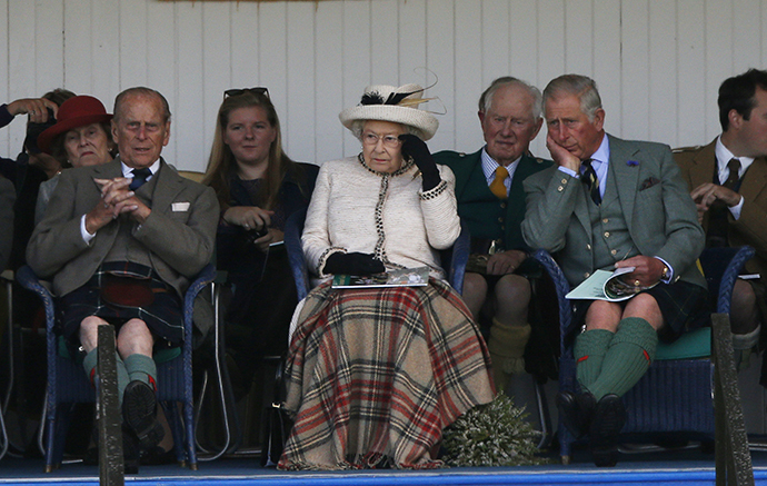 Britain's Queen Elizabeth (C), Prince Philip (L) and Prince Charles (R) watch the sack race at the annual Braemar Highland Gathering in Braemar, Scotland September 6, 2014. (Reuters / Russell Cheyne)