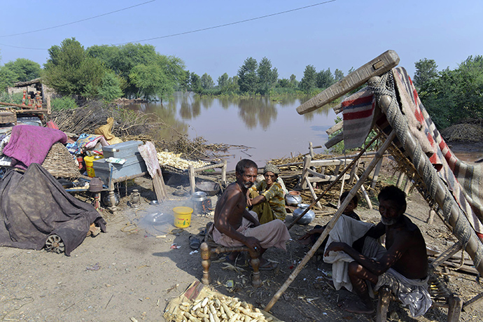 Pakistani residents affected by flooding gather on higher ground with their belongings in Jhang, in the central Punjab province on September 9, 2014 (AFP Photo / Arif Ali)