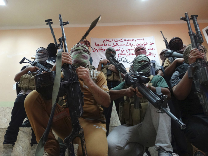 Tribal fighters carrying their weapons pose for photographs during an intensive security deployment to fight against militants of the Islamic State, formerly known as the Islamic State of Iraq and the Levant (ISIL), in the town of Haditha, northwest of Baghdad August 25, 2014. (Reuters/Osama Al-dulaimi)