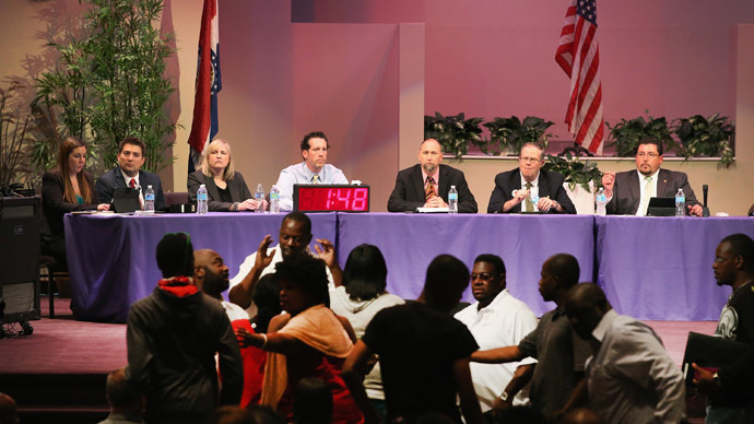Mayor James Knowles (seated R) ) and city council members wait until angry residents are calmed down during the Ferguson city council meeting on September 9, 2014 in Ferguson, Missouri. (AFP Photo/Scott Olson)