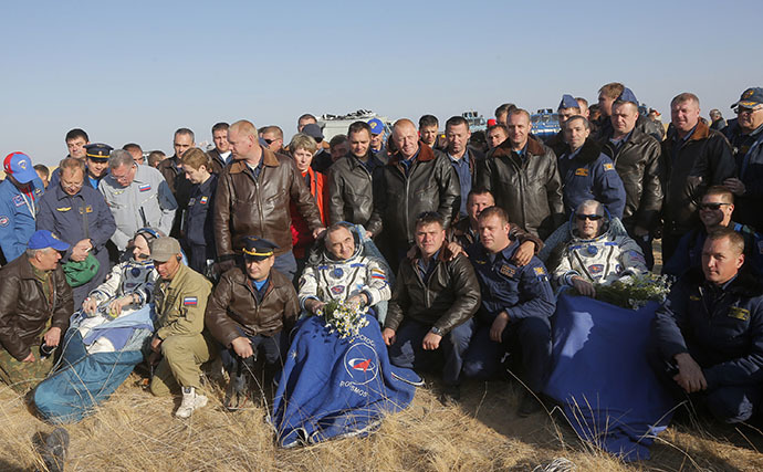 Russian search and rescue team members pose for a photo with Russian cosmonauts Oleg Artemyev (front-2nd L), Alexander Skvortsov (C) and US NASA astronaut Steven Swanson (front 2nd R) after the landing of the Soyuz TMA-12M spacecraft near the Kazakhstan city of Zhezkazgan on September 11, 2014. (AFP Photo / Maxim Shipenkov)
