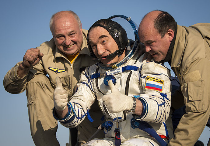 Expedition 40 Flight Engineer Alexander Skvortsov of the Russian Federal Space Agency (Roscosmos) gives a thumbs up as he is helped out of the Soyuz Capsule just minutes after he and Flight Engineer Oleg Artemyev of Roscosmos, and Expedition 40 Commander Steve Swanson of NASA, landed in their Soyuz TMA-12M capsule in a remote area near the town of Zhezkazgan, Kazakhstan on Thursday, Sept. 11, 2014. (AFP Photo / Bill Ingalls)