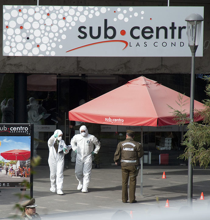 Police investigators work at the entrance to the shopping mall of the Escuela Militar subway station in Santiago on September 8, 2014. (AFP Photo / Martin Bernetti)