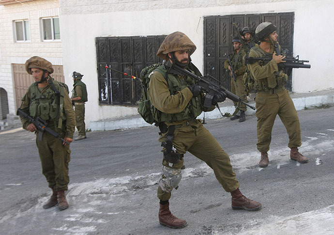 Israeli soldiers stand guard during a raid (Reuters / Abed Omar Qusini)