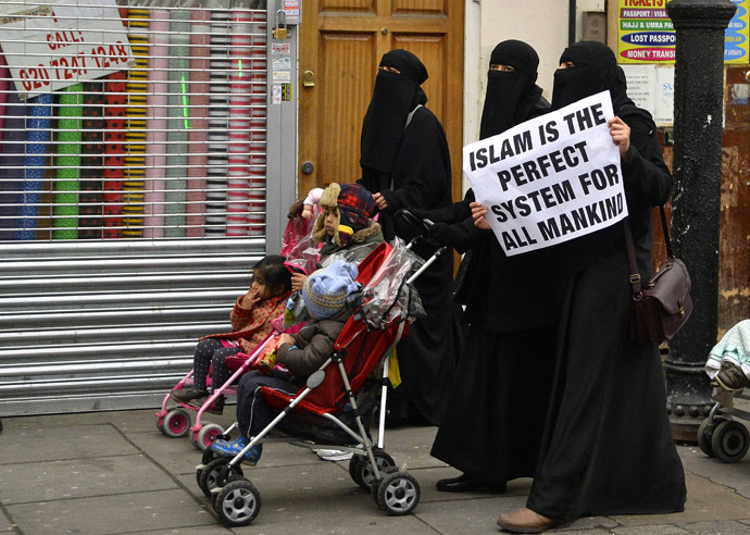 Women hold placards during a march and rally in east London December 13, 2013. (Reuters/Toby Melville)