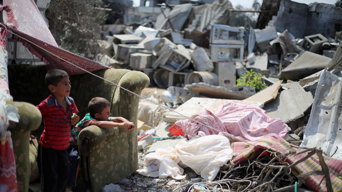 Palestinian children sit near a destroyed house in Khan Yunis in the southern Gaza Strip.(AFP Photo / Said Khatib )