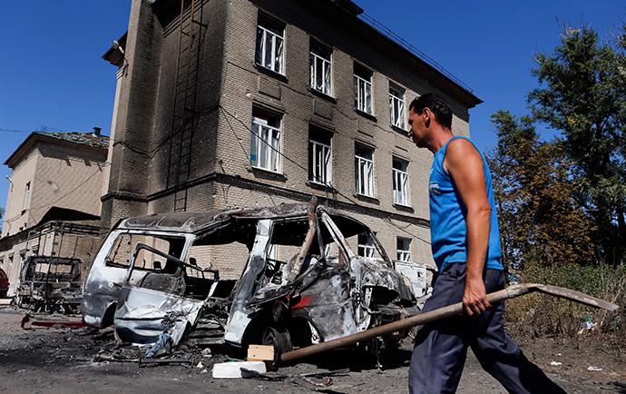 A man walks past vehicles destroyed during the recent shelling in the eastern Ukrainian town of Ilovaysk, August 31, 2014 (Reuters / Maxim Shemetov)