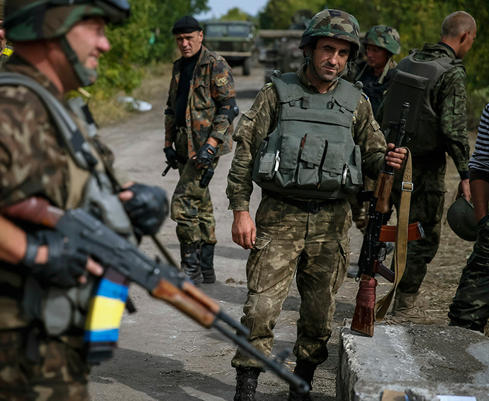 Ukrainian soldiers stand at a checkpoint near the eastern Ukrainian town of Pervomaysk September 12, 2014 (Reuters / Gleb Garanich)
