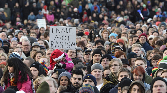 People demonstrating against nazism and racism hold a placard reading "united against racism" in the Stockholm suburb Karrtorp, Sweden on December 22, 2013. (AFP/TT News Agency)