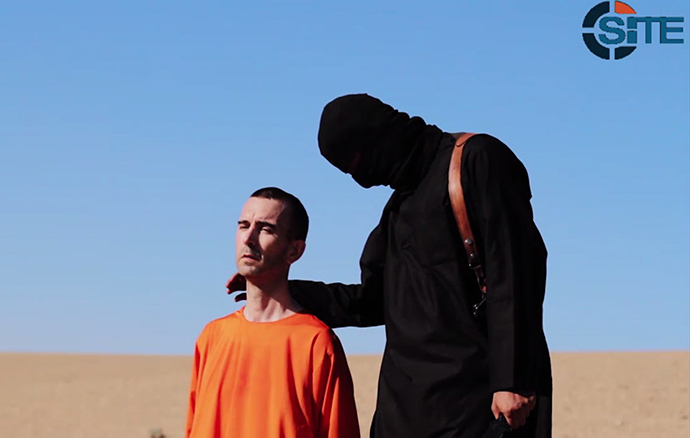An image grab taken from a video released by the Islamic State (IS) and identified by private terrorism monitor SITE Intelligence Group on September 13, 2014 purportedly shows British aid worker David Haines dressed in orange and on his knees in a desert landscape speaking to the camera before being beheaded by a masked militant (R) (AFP Photo / HO)