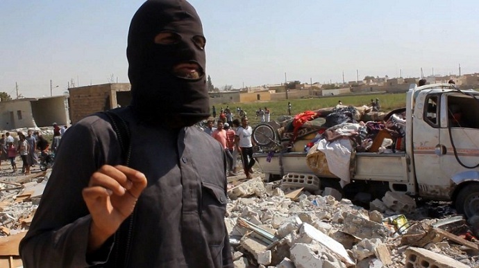 A jihadist from the Islamic State (IS) group standing on the rubble of houses after a Syrian warplane was reportedly shot down by IS militants over the Syrian town of Raqa. (AFP/AFPTV screenshot)