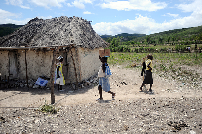 Children carry relief food in Baie des Moustiques on the final day of food distribution by The World Food Programme (WFP) to families in the drought affected areas of northwest Haiti. (AFP Photo / Hector Retamal)