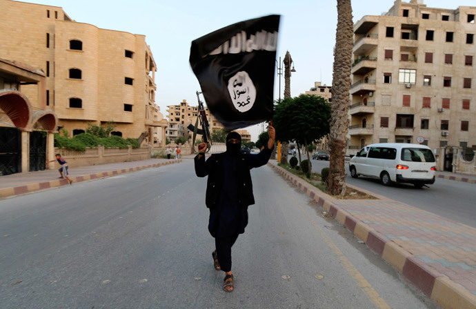 A member loyal to the Islamic State in Iraq and the Levant (ISIL) waves an ISIL flag in Raqqa (Reuters / Stringer)