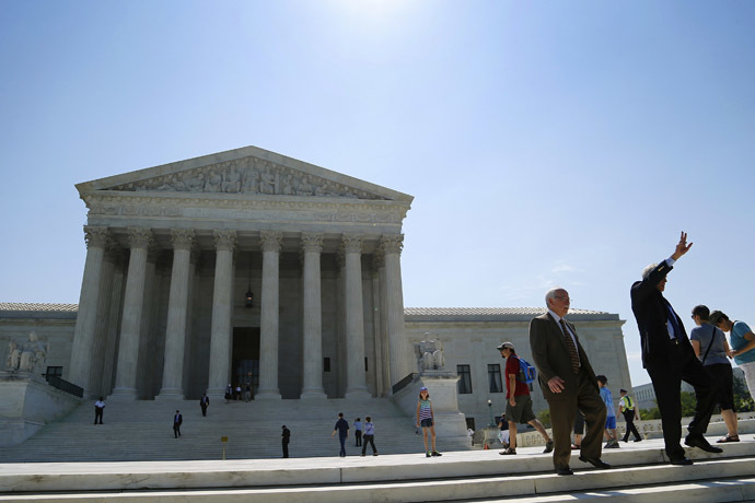 A man hails a taxi upon exiting the U.S. Supreme Court building in Washington June 16, 2014. (Reuters/Jonathan Ernst)