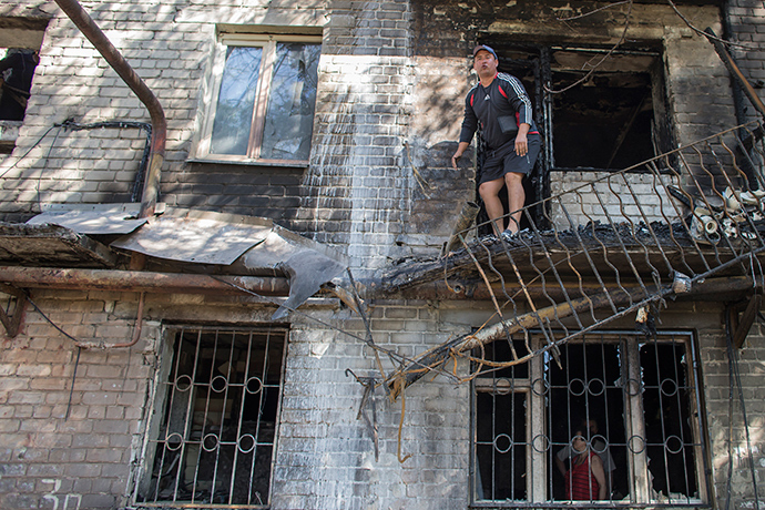 A man stands on the balcony of a building that was recently shelled in Donetsk, eastern Ukraine, September 17, 2014 (Reuters / Marko Djurica)