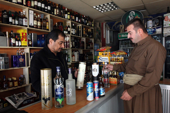A shopkeeper displays a selection of alcoholic drinks to a Kurdish man at a store in Arbil, 310 km (190 miles) north of Baghdad (Reuters/Azad Lashkari)