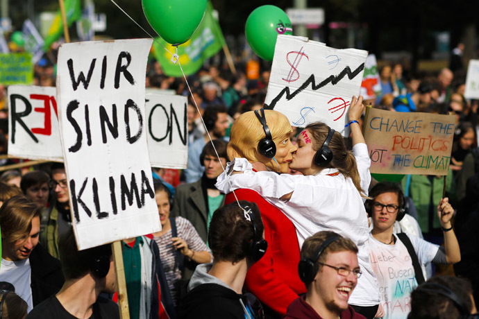 People hold banners and dance during a Climate Change March demanding politicians take tougher action to protect the climate in Berlin, September 21, 2014. (Reuters/Thomas Peter)