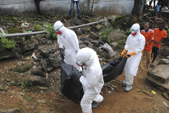 Health workers remove the body of Prince Nyentee, a 29-year-old man whom local residents said died of Ebola virus in Monrovia September 11, 2014. (Reuters/James Giahyue)
