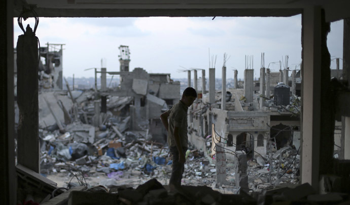 A Palestinian stands in his badly damaged house as the ruins of houses, which witnesses said were destroyed during the seven-week Israeli offensive, are seen in the east of Gaza City August 31, 2014. (Reuters/Suhaib Salem)