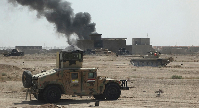 A convoy of Iraqi security forces is seen during a patrol, as smoke rises from clashes with Islamic State (IS) militants, on the outskirts of Ramadi, September 19, 2014. Picture taken September 19, 2014 (Reuters / Osama Al-dulaimi)